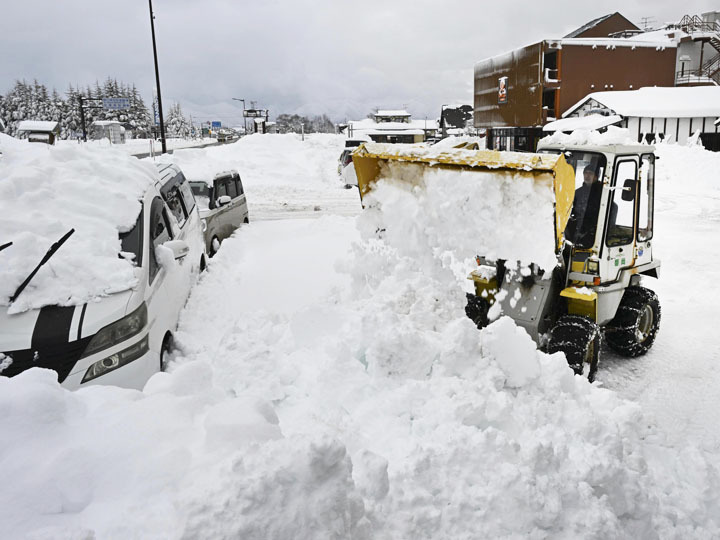 膝の高さまで積もった雪。町民が除雪する中、雪が舞っていた＝9日午前11時5分、猪苗代町