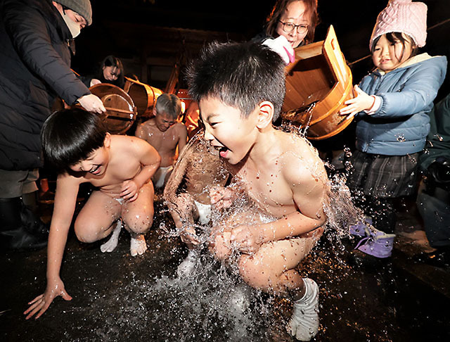 冷水を浴び、声を上げながら耐える参加者たち＝酒田市・飛鳥神社