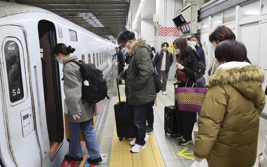 大きな荷物を持って新幹線に乗り込む人たち（4日午前、福岡市博多区のJR博多駅で）＝秋月正樹撮影