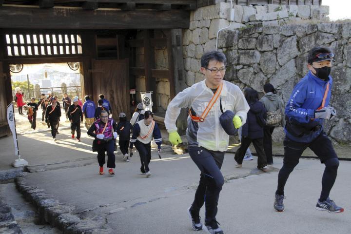 息を切らせながら本丸広場のゴールを目指すランナー＝1日午前、松山市丸之内