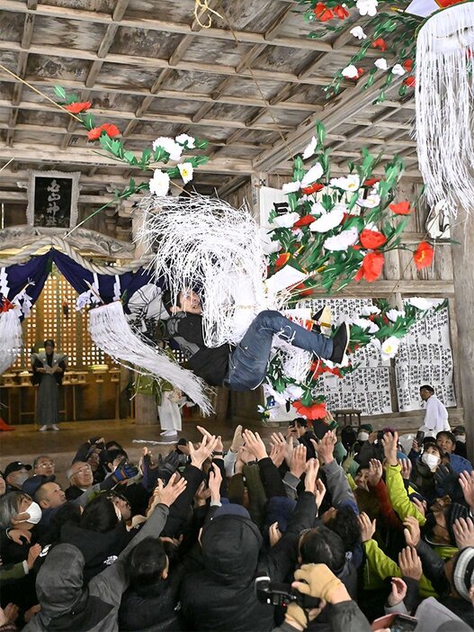 花奪い祭りで、しがみついた花笠ごと落下する若者＝６日午後２時３６分、郡上市白鳥町長滝、長滝白山神社（撮影・堀尚人）