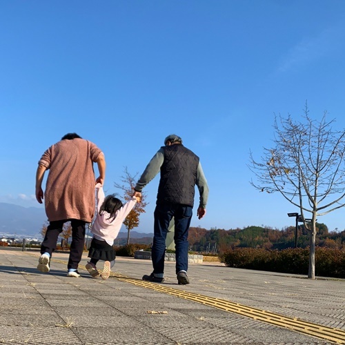 孫と散歩する祖父母