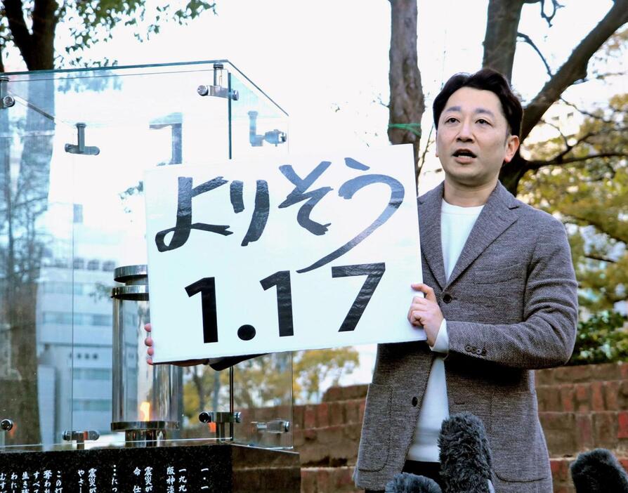 灯籠でかたどる文字「よりそう　１・１７」を掲げる藤本真一さん＝神戸市中央区加納町６、東遊園地