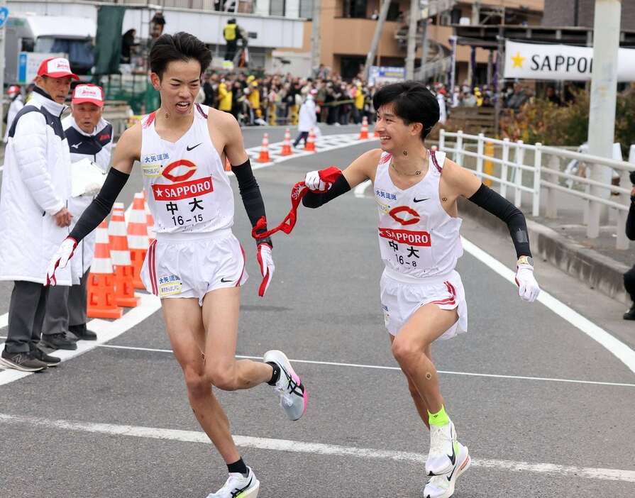 平塚中継所でタスキをつなぐ中大7区の岡田開成（左）と中大8区の佐藤大介（代表撮影）