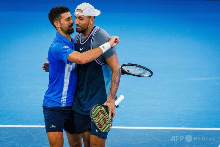 テニス、ブリスベン国際、男子ダブルス2回戦。試合後に抱き合うノバク・ジョコビッチ（左）/ニック・キリオス組（2025年1月1日撮影）。【翻訳編集】 AFPBB News