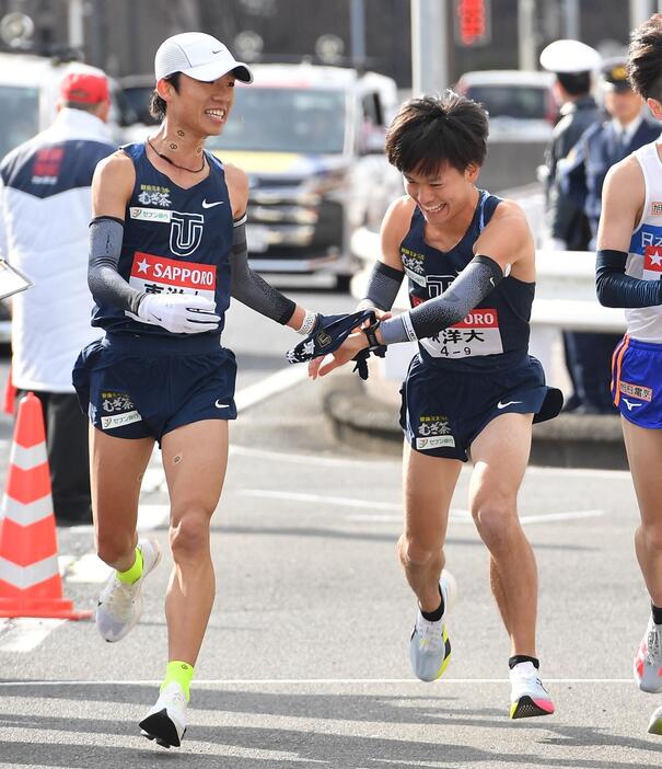 　網本佳悟からたすきを受ける東洋大・吉田周（撮影・開出牧）