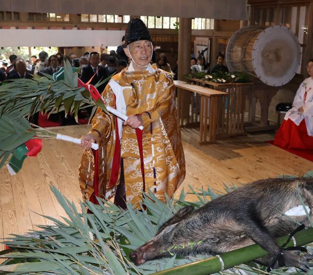 イノシシが供えられた神前で、笹振り神楽を奉納する後藤俊彦宮司