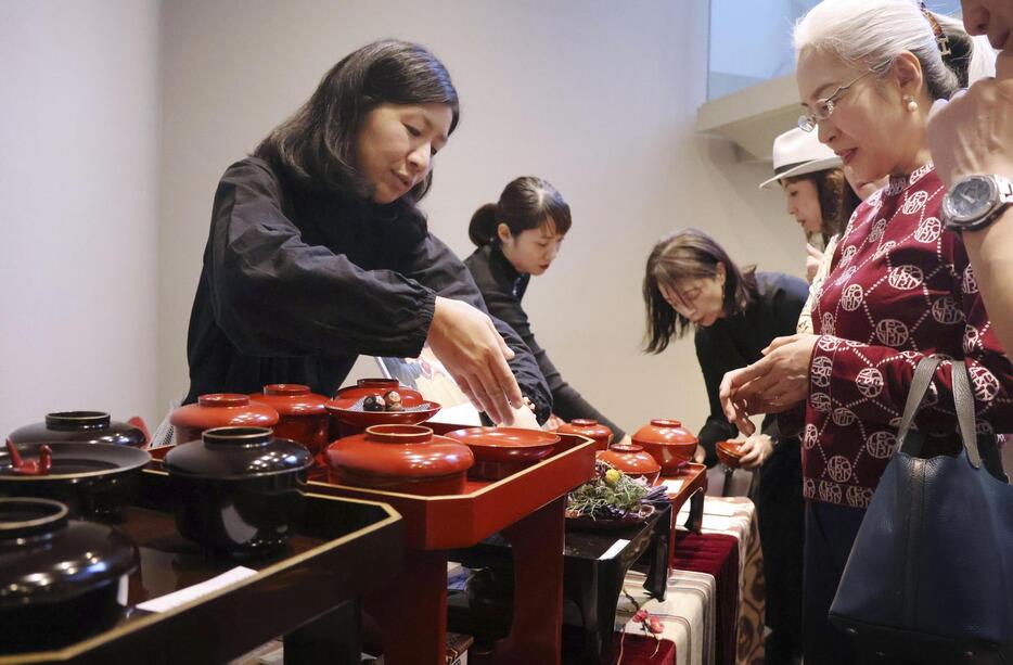 舞台「武士の献立」の会場で、輪島塗の漆器を販売する影山朋子さん（左）＝2024年11月、東京・赤坂の草月ホール