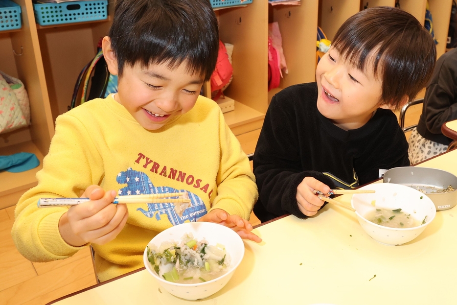 「七草がゆ」を食べ、笑顔を浮かべる園児たち