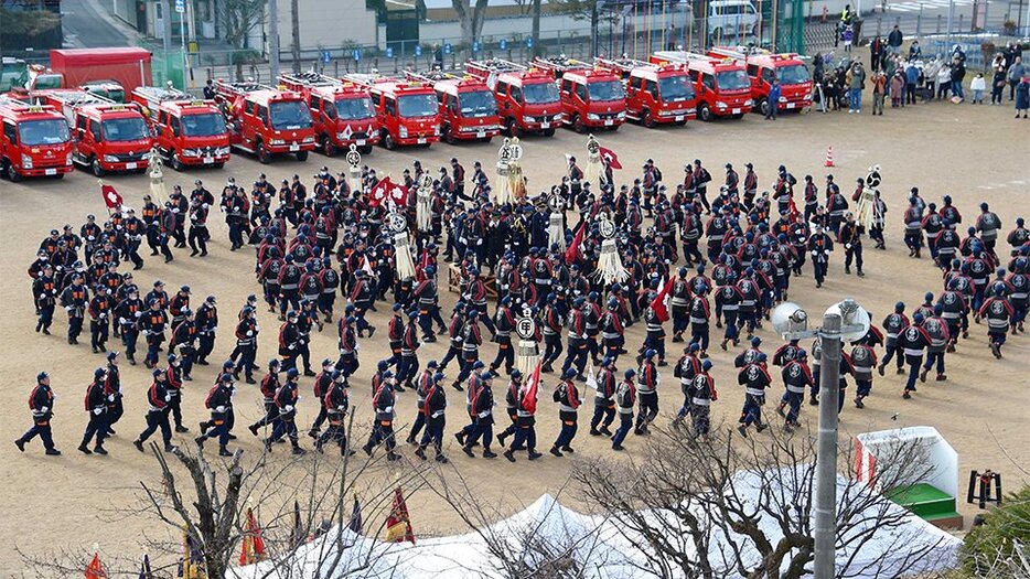 渦を巻くように進む「舞い込み」を披露する団員たち＝５日午前１０時２１分、高山市総和町、西小学校グラウンド