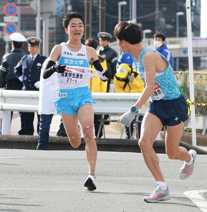 関東学生連合８区・秋吉拓真(左）から９区・古川大晃にタスキが渡る（カメラ・堺　恒志）