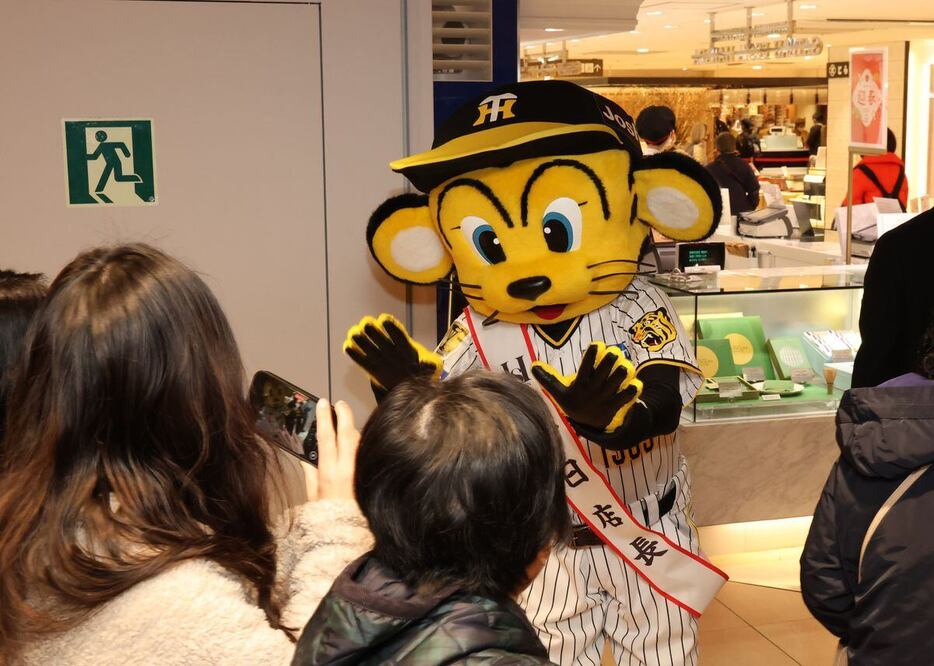 一日店長としてハイタッチで入店する客を出迎えるトラッキー＝大阪市北区の阪神百貨店（山田耕一撮影）