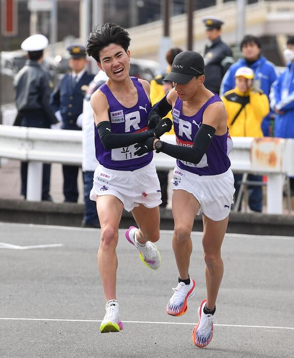 　安藤圭佑（右）にたすきを渡す立教大・山口史朗（撮影・開出牧）