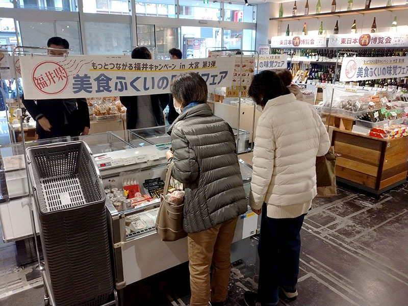 福井県の味覚が大宮に集結、吟味する買い物客＝7日、さいたま市大宮区のまるまるひがしにほん