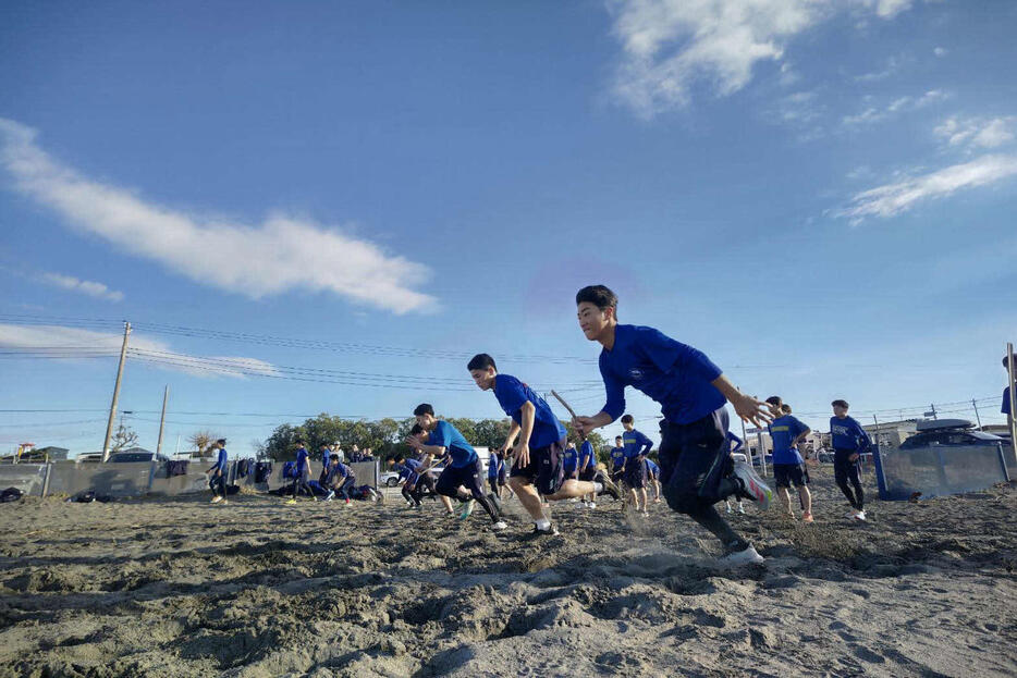 中央学院・館山キャンプ、砂浜でリレーで走り込みをする中央学院の野手たち（撮影・保坂淑子）