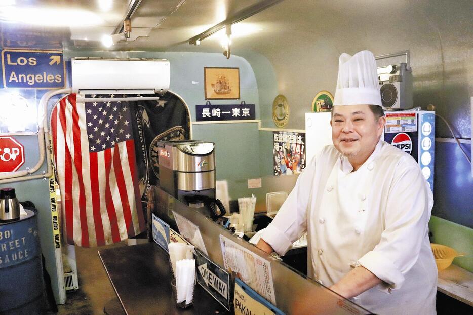 アメリカをイメージさせるグッズが並ぶ店内で、平和への思いを語る鈴山さん