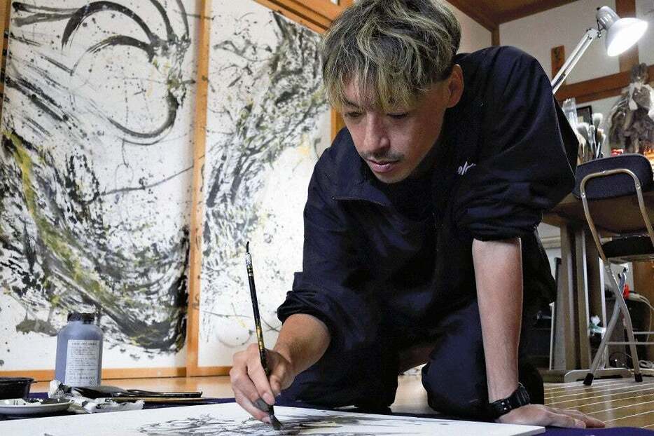 墨絵の制作に取り組む。下絵に時間をかけた後は、迷いなく筆を動かす（福井市で）