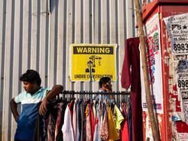 Clothes for sale at a street side stall in front of a construction site in Mumbai. Photographer: Abeer Khan/Bloomberg