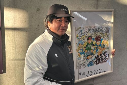 宮尾氏から贈呈された『イナズマイレブン』のイラストパネルを手にする上田西の白尾監督