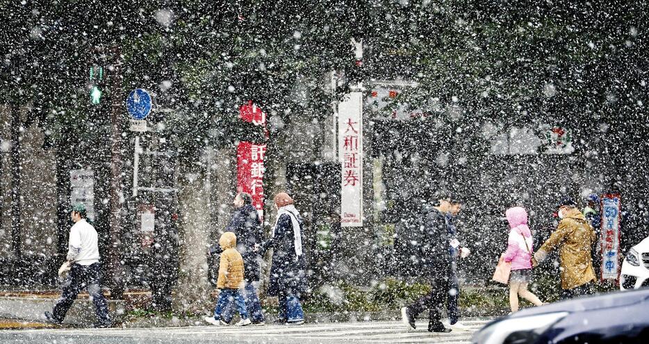 雪が降るなかを行き交う人たち（9日午後2時50分、福岡市・天神で）＝秋月正樹撮影