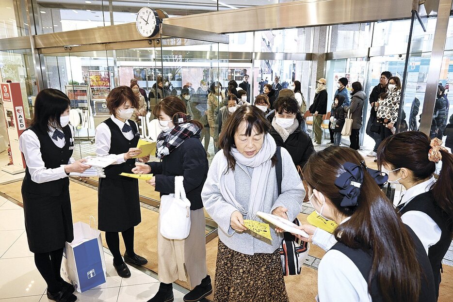 午前10時の開店とともに「大入福袋」の整理券を受け取り、入店する客たち（井上本店）