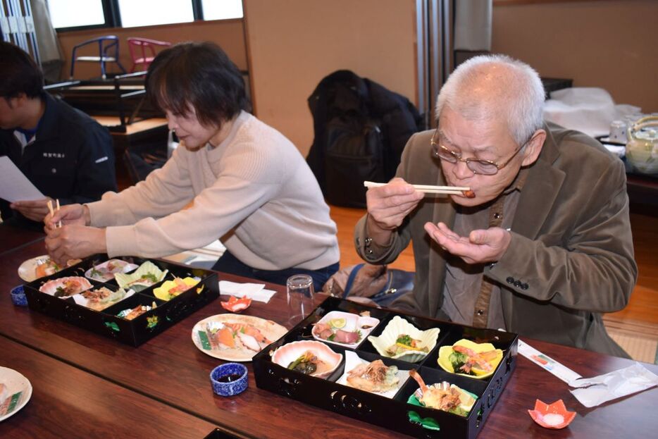 養殖車エビを使った料理を試食する関係者=那賀町大久保のもみじ川温泉