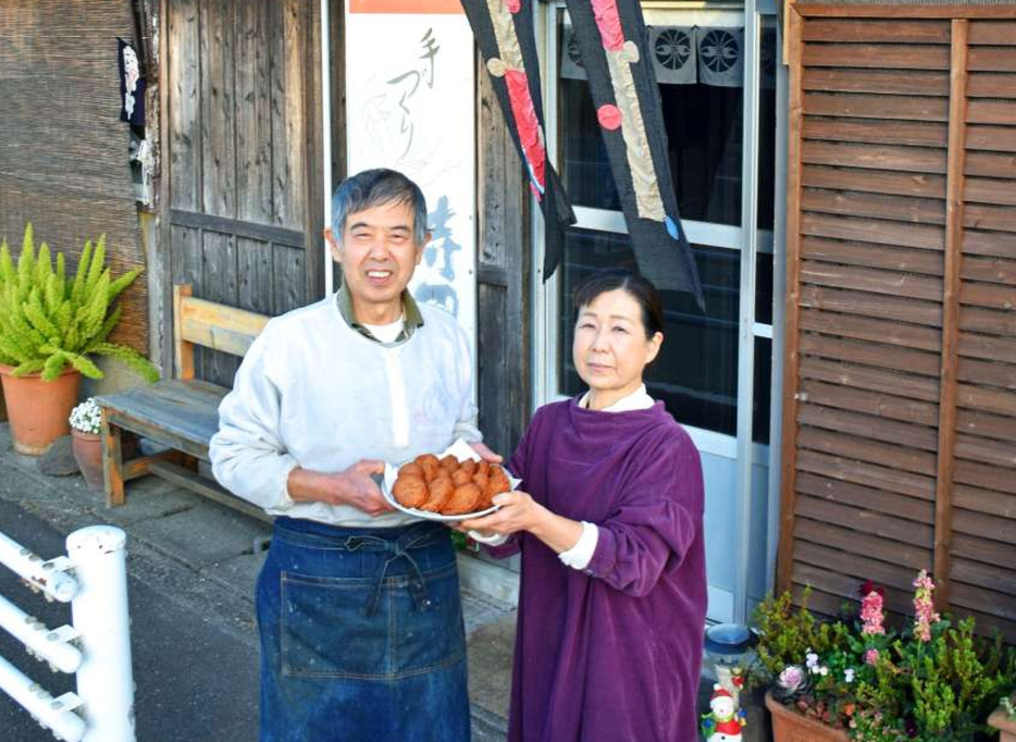 さつま揚げを手に店前で笑顔を見せる寺田成弘さん（左）、加世さん