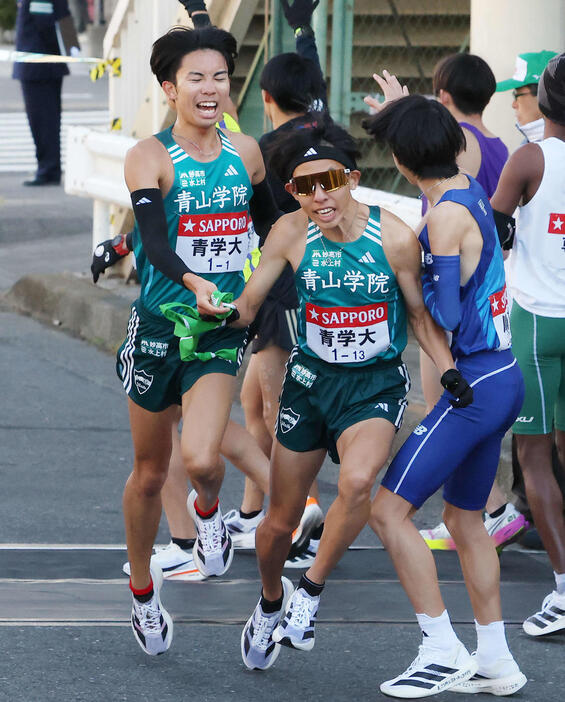 鶴見中継所を10位でタスキリレーする青学大1区宇田川（左）と2区黒田朝（撮影・河田真司）