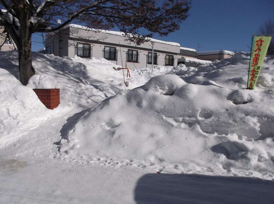 雪捨て場になっている公園。遊具が隠れるほど高く積み上がっている＝10日、青森市（福田徳行撮影）