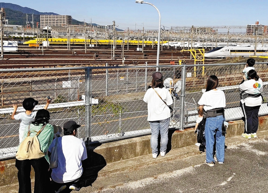 「新幹線の見える丘」から博多総合車両所に並ぶ車両を見学する親子ら