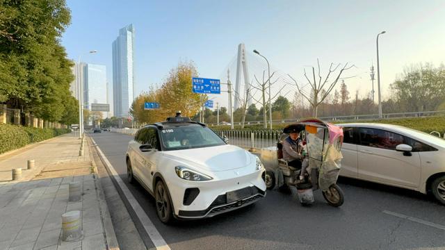 武漢市内を走る百度の自動運転タクシー。一般の車やバイクと並走していた=2024年12月24日、中国・湖北省、小早川遥平撮影