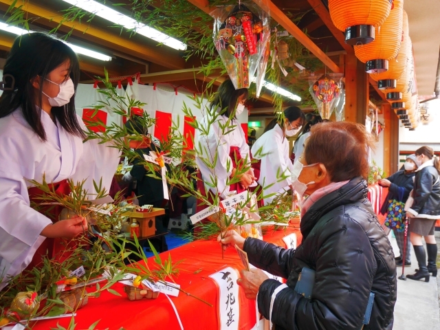 参拝者に吉兆ササを授与する福娘=5日、奈良市南市町の南市恵毘須神社