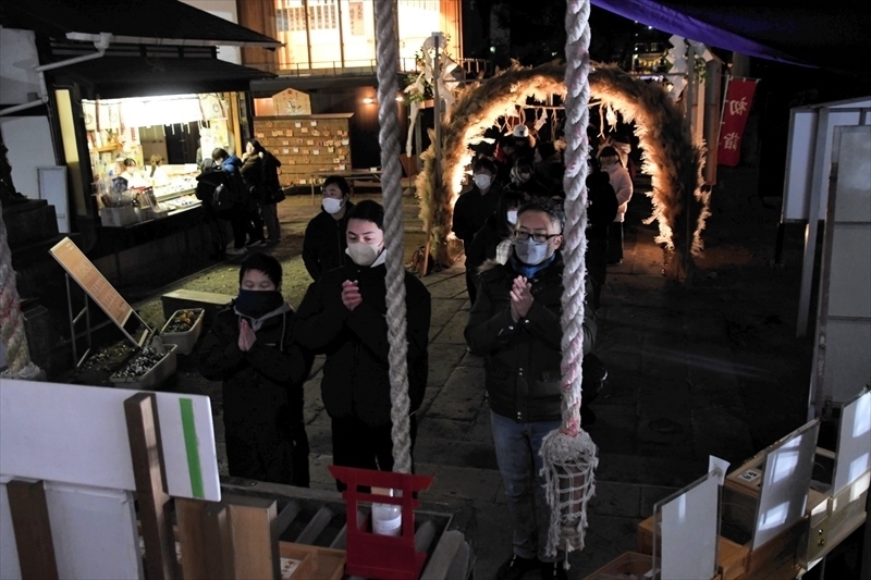 午前０時を回り、手を合わせる参拝客=神炊館神社