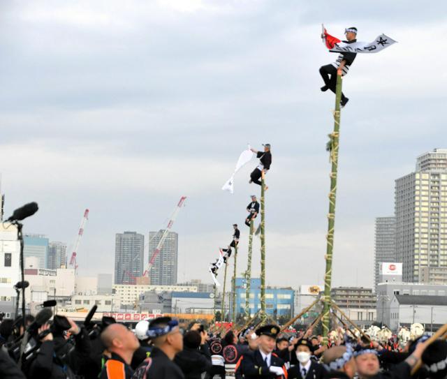 江戸時代からの伝統の「はしご乗り」を披露する人たち。「がんばろう日本」と書かれた幕を掲げた=2025年1月6日午前11時6分、東京都江東区有明3丁目、藤田大道撮影