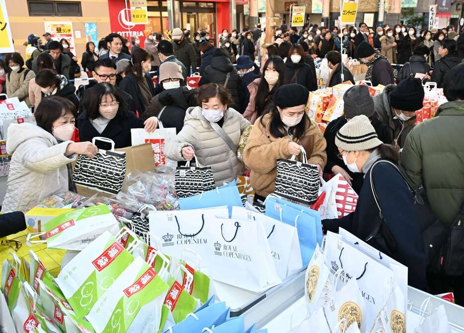 初商いで福袋を求める買い物客＝２日、鹿児島市の天文館ベルク広場