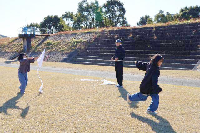 向原竹香クラブ主催のたこ揚げ大会で、手作りのたこを宙に浮かそうと頑張る子どもら