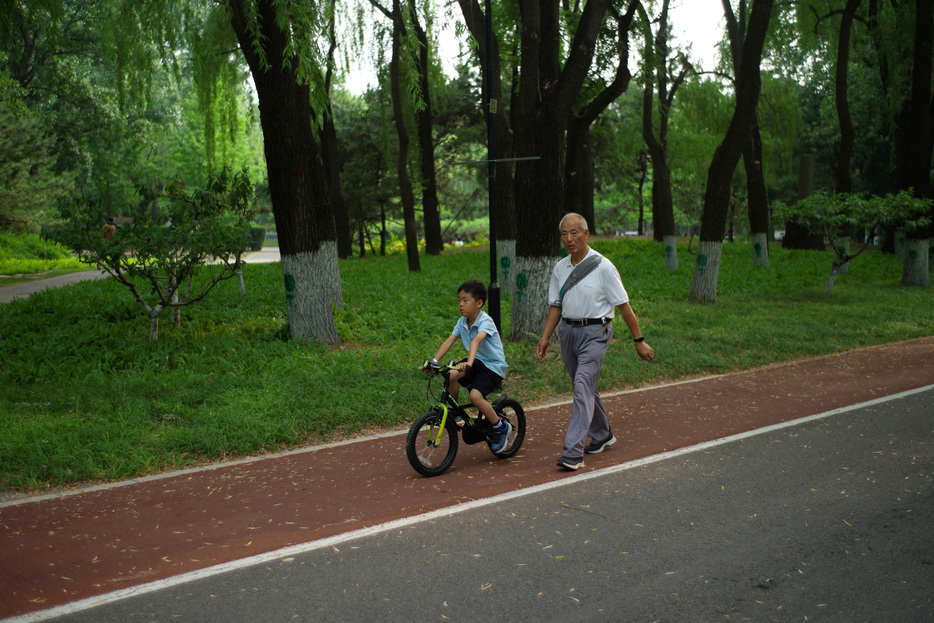 １月６日、中国政府が全国的な認知症対策を始動した。写真は２０２４年５月、北京の公園で散歩する高齢者と子供（２０２５年　ロイター/Tingshu Wang）