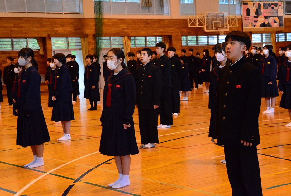 3学期のスタートを切り、始業式で校歌を歌う名瀬中学校の生徒ら＝8日、鹿児島県奄美市名瀬