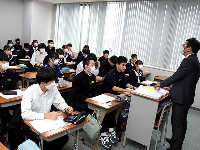 講師（右）の話を聞く中学３年の受講生たち＝富山育英センター富山本部校中学部