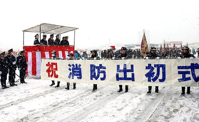 夏野市長らが見守る中、分列行進する消防団員ら