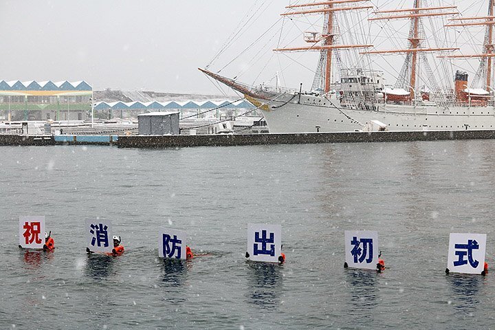 帆船海王丸の前で初泳ぎを披露する潜水隊