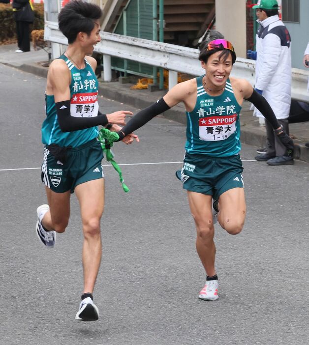 青学大９区・田中悠登（左）から、青学大１０区・ 小河原陽琉にタスキが渡る　（カメラ・佐々木　清勝）