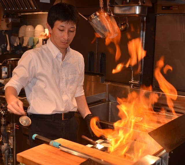 フランベするスタッフ。体験的な楽しみも提供している（京都市中京区寺町通蛸薬師上ル・京都和麺　諭吉本舗）