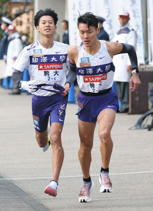 小田原中継所で伊藤蒼唯からたすきを受け取る駒大・佐藤圭汰（右）