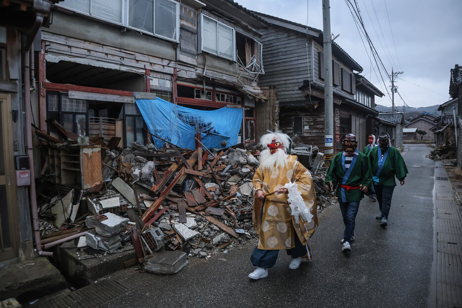 能登半島地震と昨年９月の豪雨で被災した石川県輪島市門前町の集落で、伝統行事「アマメハギ」が２年ぶりに行われた。仮面を着けた男たちが家々を回り、厄を払った＝２日午後