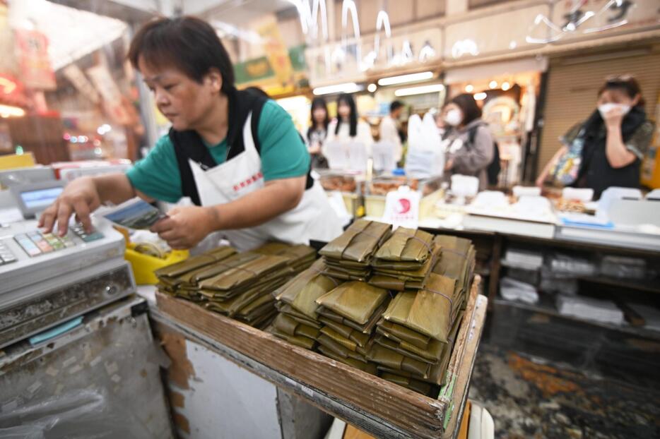 蒸し上がったムーチー（手前）と、買い物客の対応に追われる店内＝6日、那覇市松尾の松原屋製菓（ジャン松元撮影）