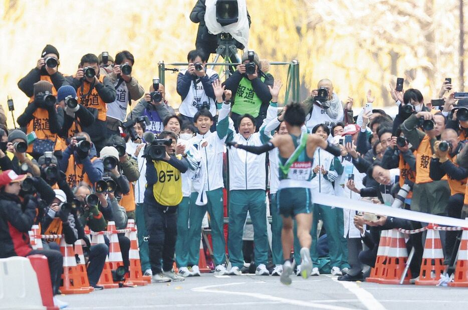 ゴールするアンカー・小河原陽琉（手前）を迎える原晋監督（中央）、青学大の選手ら