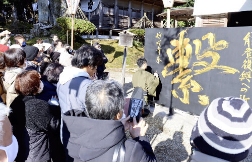 黒いパネルには金色で「繋」と記された（１日、石川県羽咋市で）＝平松千里撮影