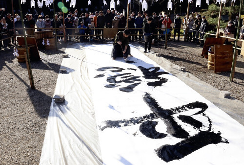 「平穏無事」と力強く記す阿部さん（中央）（１日、石川県羽咋市で）＝平松千里撮影