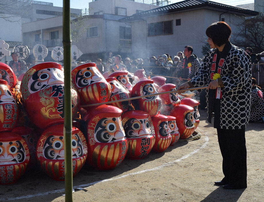 だるまを供養するお焚（た）き上げで点火する前橋市の小川晶市長（右）＝同市で２０２５年１月９日午前１０時４３分、田所柳子撮影